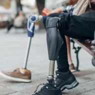 A person with a prosthetic leg sitting on the ground.